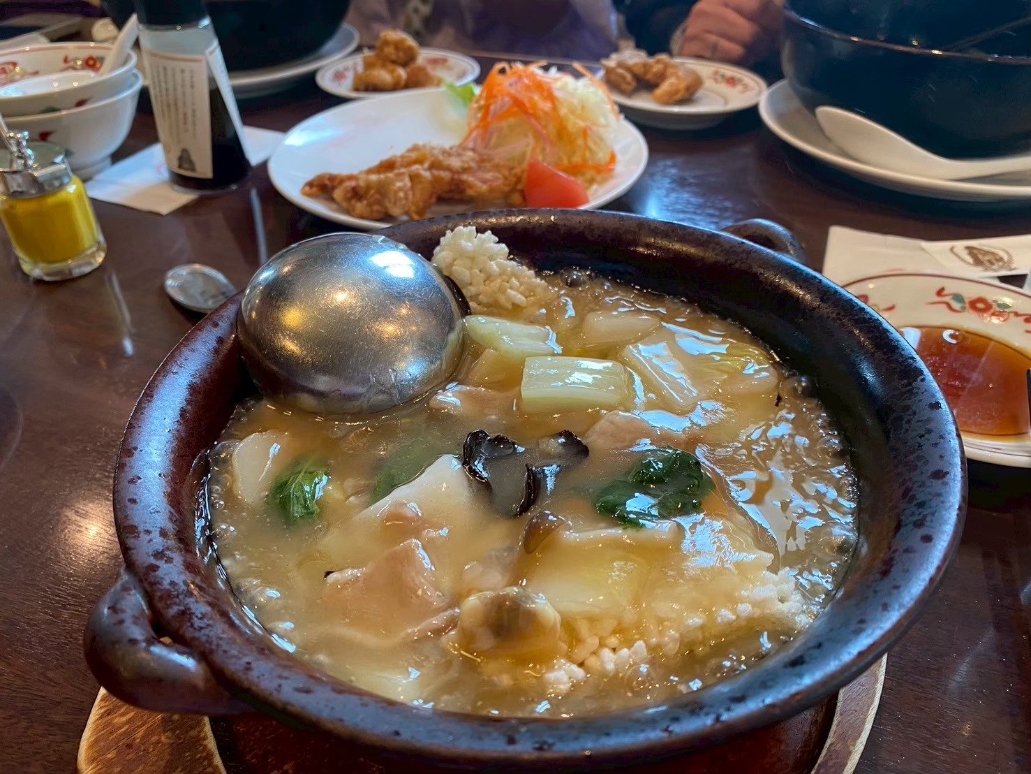 Cuenco de barro con arroz, verduras y marisco en salsa espesa